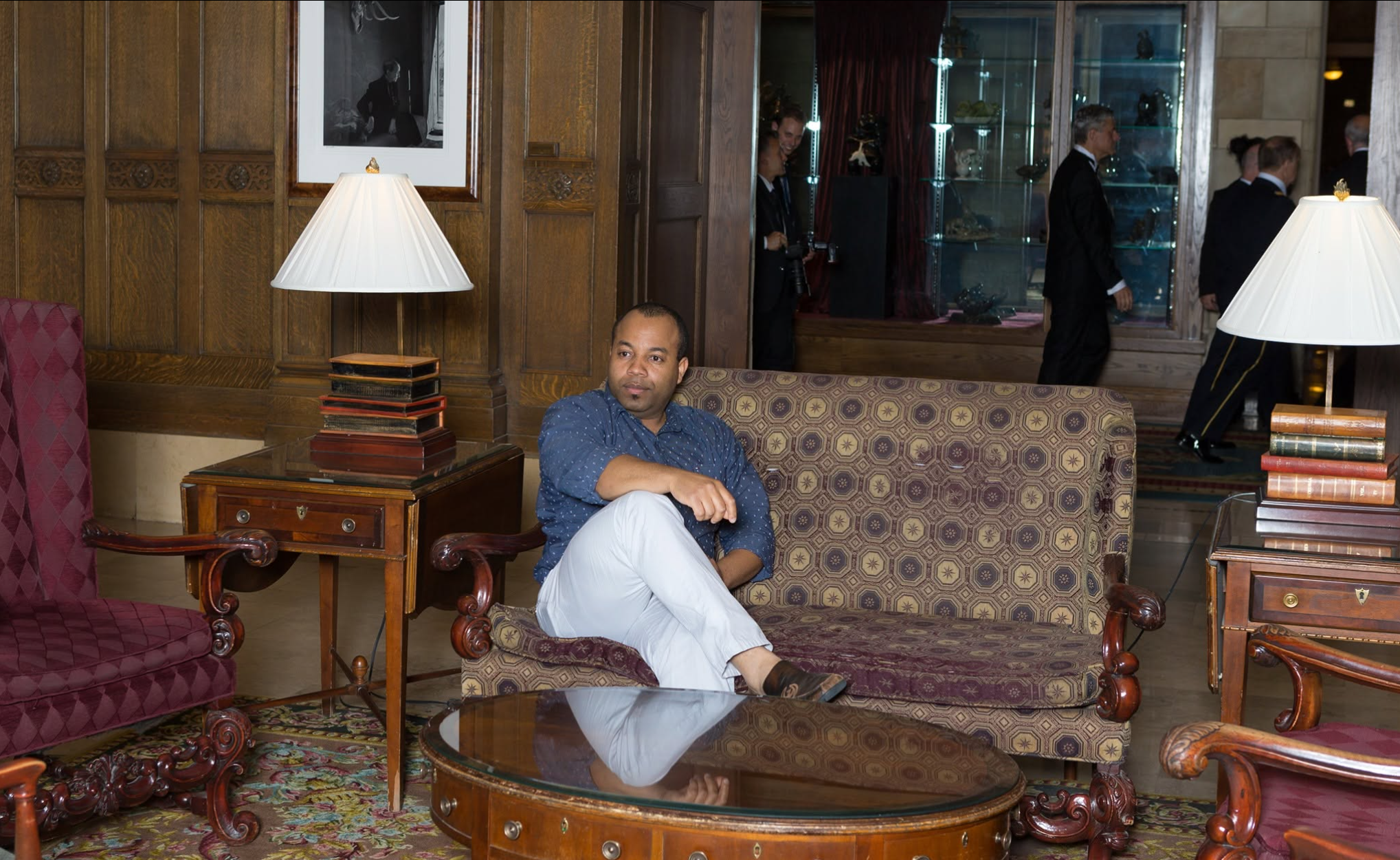 Reginald David assis dans un salon aux boiseries chaleureuses